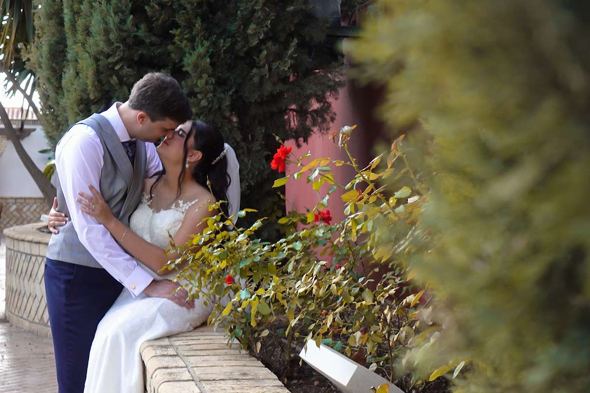 novios abrazados en el jardín entre flores después de la ceremonia, en el vídeo de su boda civil, un recuerdo inolvidable de su boda